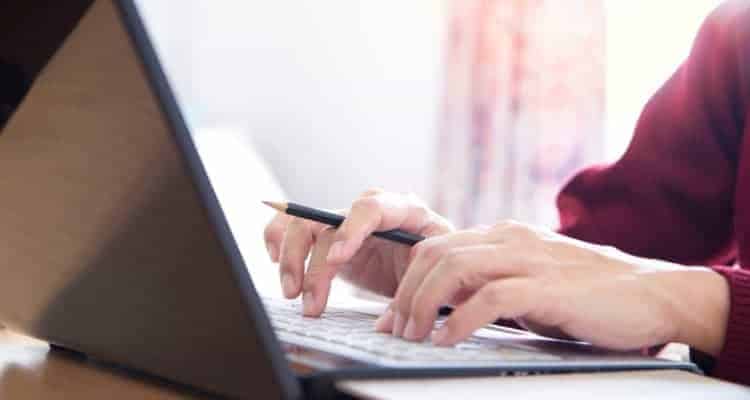 a nurse writing on a laptop