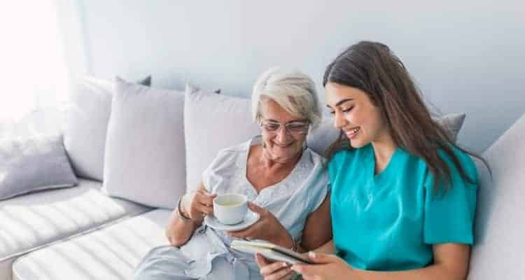 a nurse talking to a patient in their home