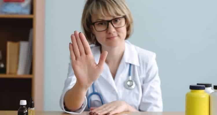 healthcare worker holding hands up to stop