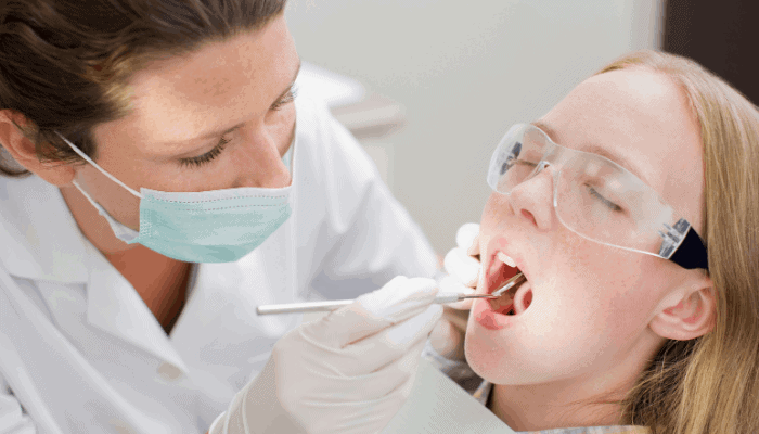 dental hygienist looking at patients teeth