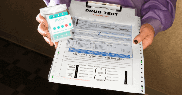 paperwork and cup for drug test