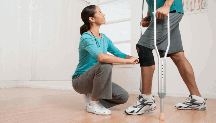 physical therapist looking at patients knee