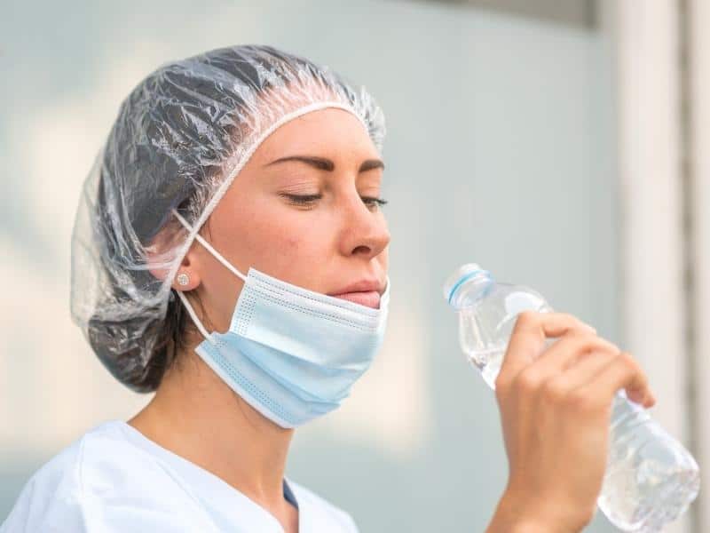 a nurse drinking water to stay hydrated