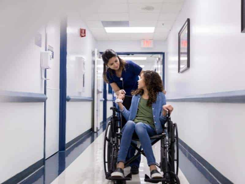 a nurse aide helping patient in wheelchair