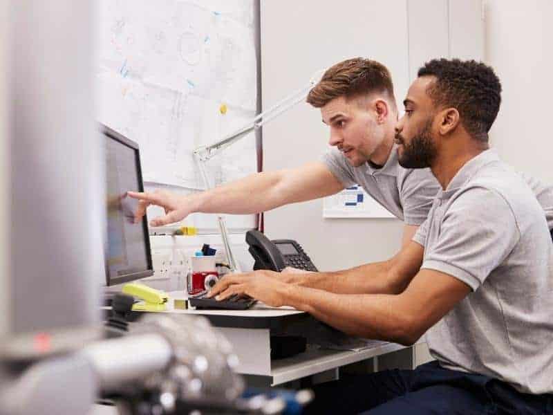 two engineers looking at computer screen