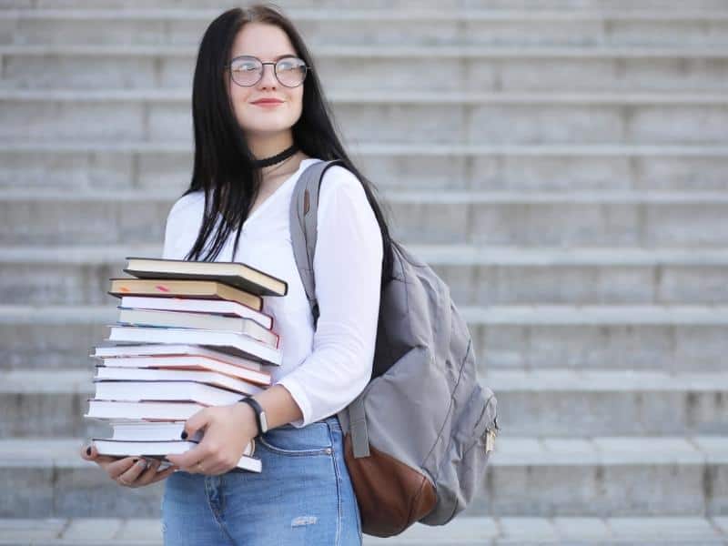 smiling woman carrying books