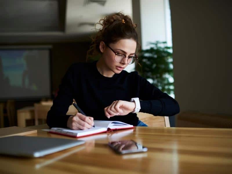 studying woman looking at her watch