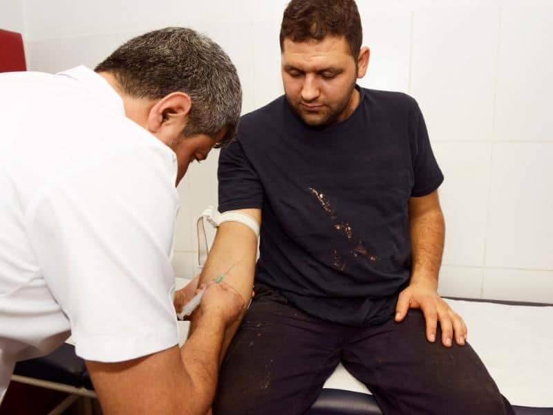 occupational physician giving a worker an injection