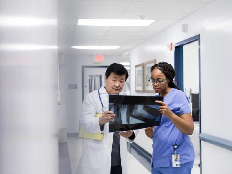 male and female orthopedic doctors look at an x-ray 