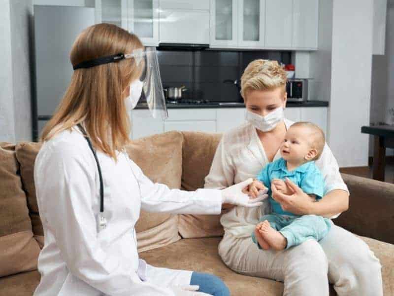 mother holding son while doctor sitting near