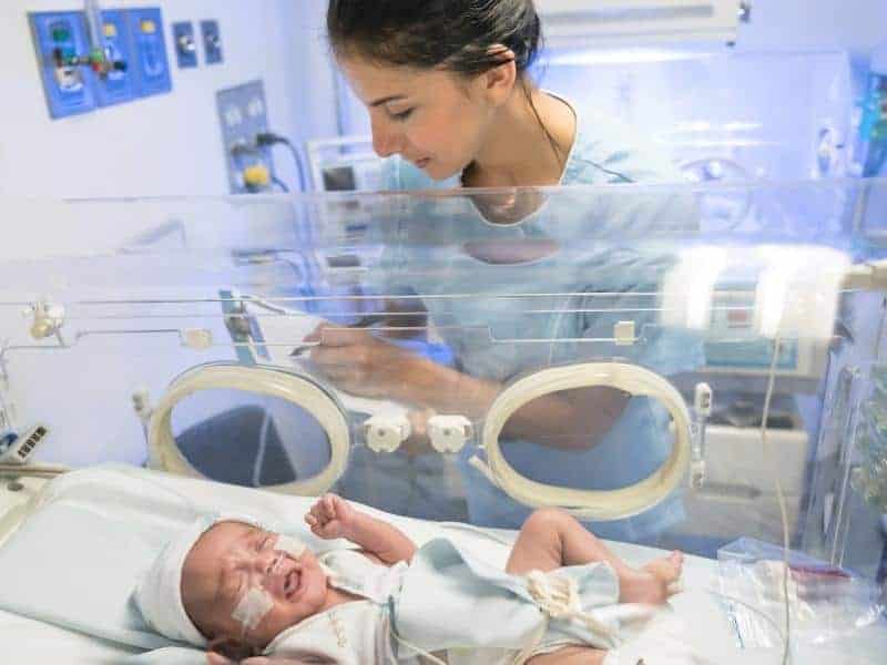 neonatal nurse checking a premature newborn baby