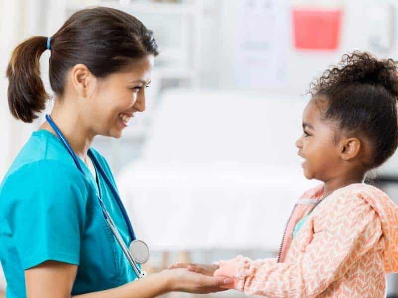 pediatric nurse smiling at a young patient