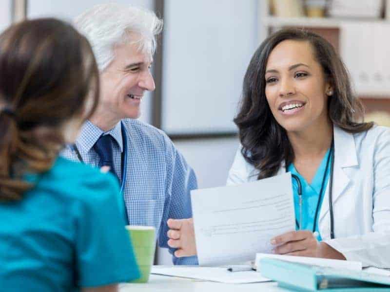 medical professionals interview a young woman for nursing position