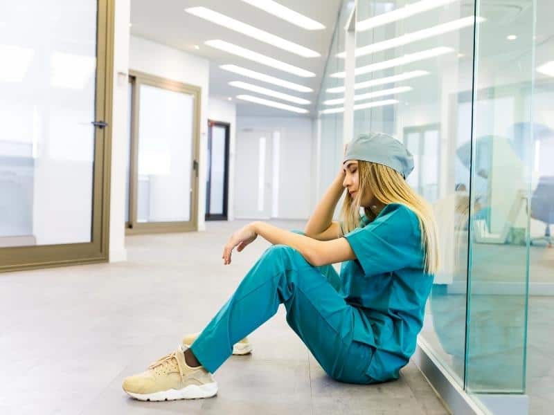 a nurse sitting down feeling incompetent and sad