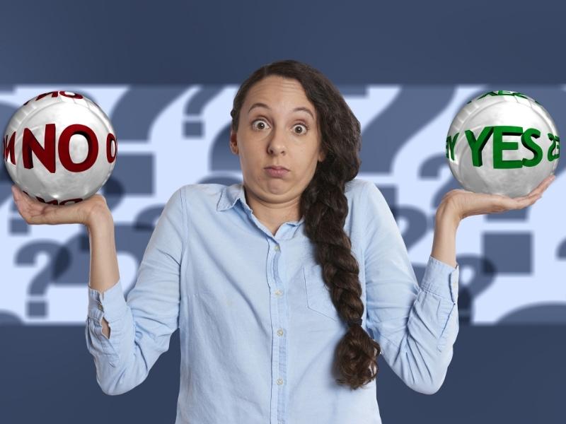 woman holding two balls that say yes or no