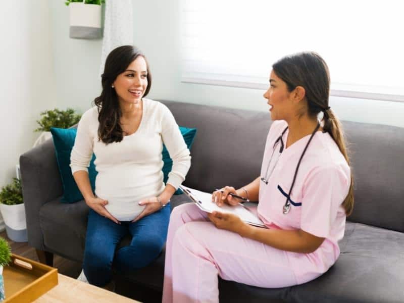 Article Image -  Female nurse talking about the due date with an expectant mother