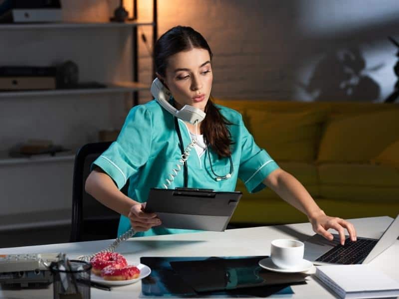 Article Image -   nurse in uniform talking on telephone and holding clipboard during night shift