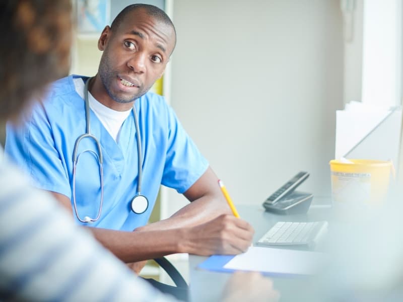 stock image - black american nurse writing